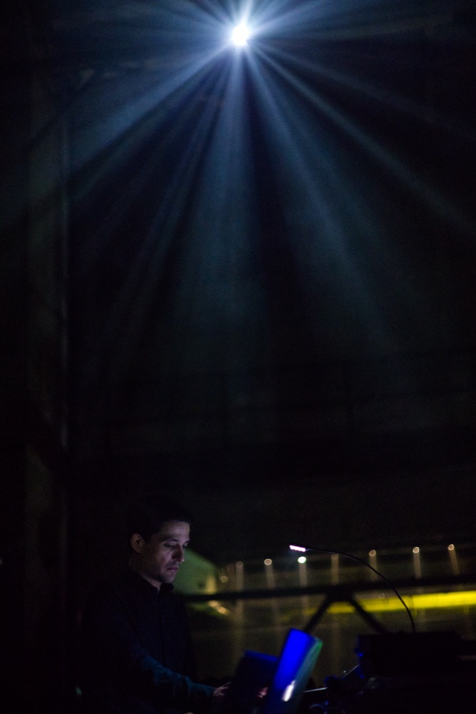 Sergio Luque performing under a single light beam